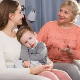 Adult female with her mother are talking about life and parenting child at home.